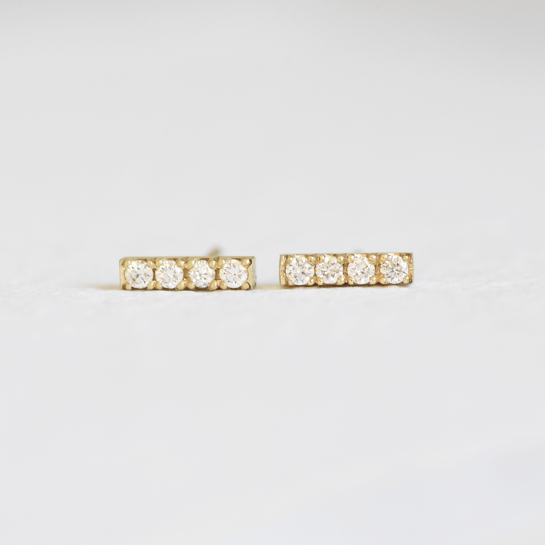 Hand Engraved By Rhode Island Jeweler, Corkie Bolton. This image is of 18k yellow gold bar studs with four diamonds in each earring.
