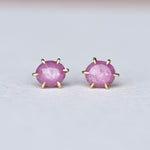 Close-up of Fierce Pink Sapphire Studs in 18k Gold, sparkling with vivid pink sapphires against a soft background.