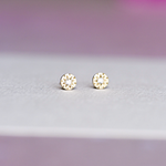 Close-up of Funfetti Engraved Diamond 14k gold studs on a white background, showing hand-engraved texture and round diamonds.