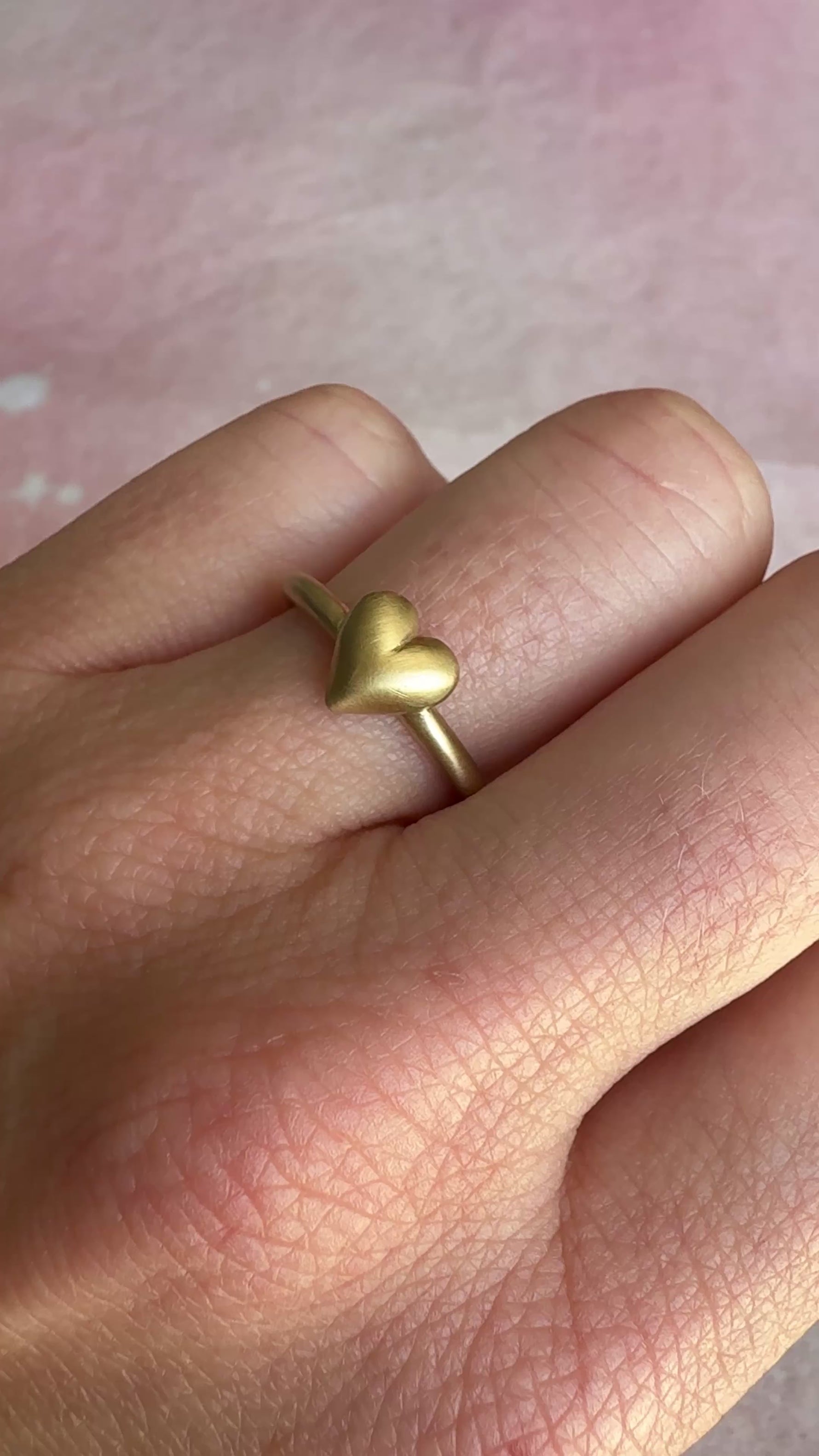 The Puffy Heart Ring captured in motion, highlighting its reflective qualities.
