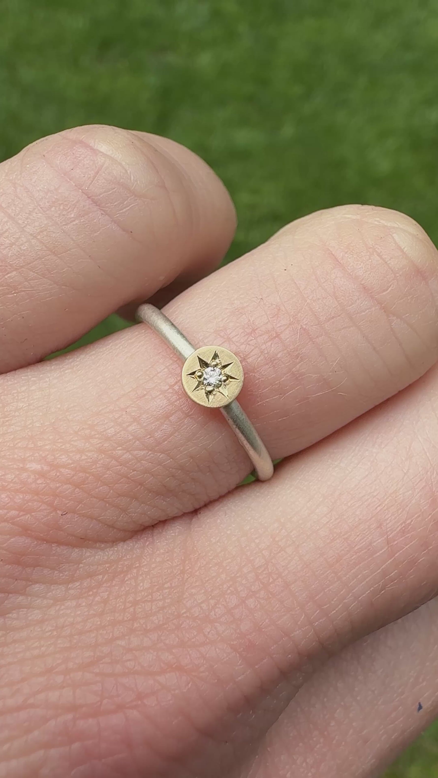 Video of sterling ring with 14k yellow gold disc hand engraved with a diamond star setting. On a hand.