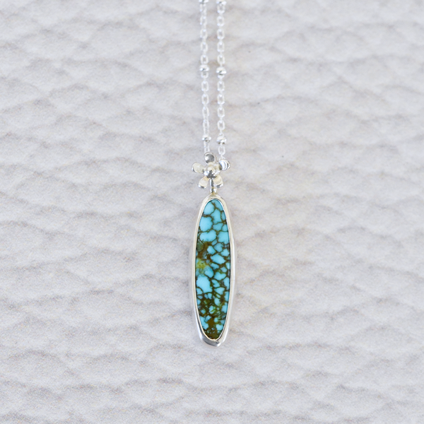 Sterling silver and american turquoise necklace featuring a tiny hand fabricated flower.