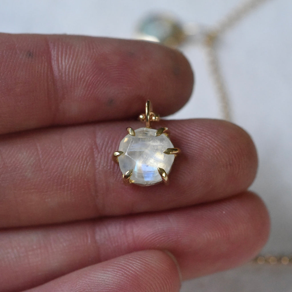 18k yellow gold six prong charm featuring moonstone.