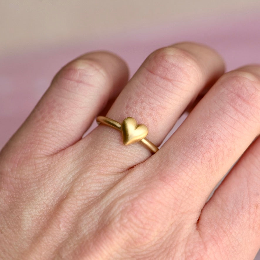 Hand wearing the Puffy Heart Ring by Corkie Bolton Jewelry, showcasing its bold, sculptural 14k recycled gold heart design and comfortable fit on the finger.