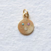 This charm is crafted from recycled 18k yellow gold, engraved and set with a 2.5mm SI1 diamond, a 1.8mm purple sapphire (treated) and a 2mm Sleeping Beauty turquoise cabochon all of which were responsibly sourced. 