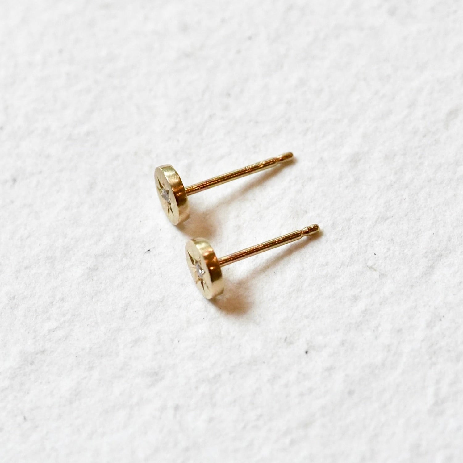 Side profile of petite, celestial hand engraved 14k gold and diamond stud earrings by Corkie Bolton Jewelry