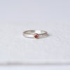 Front view of pink sapphire ring: A front-facing image showcasing a pink "berry" sapphire cabochon set in a 14k yellow gold engraved bezel, mounted on a satin-finished sterling silver band with an abstract floral texture.