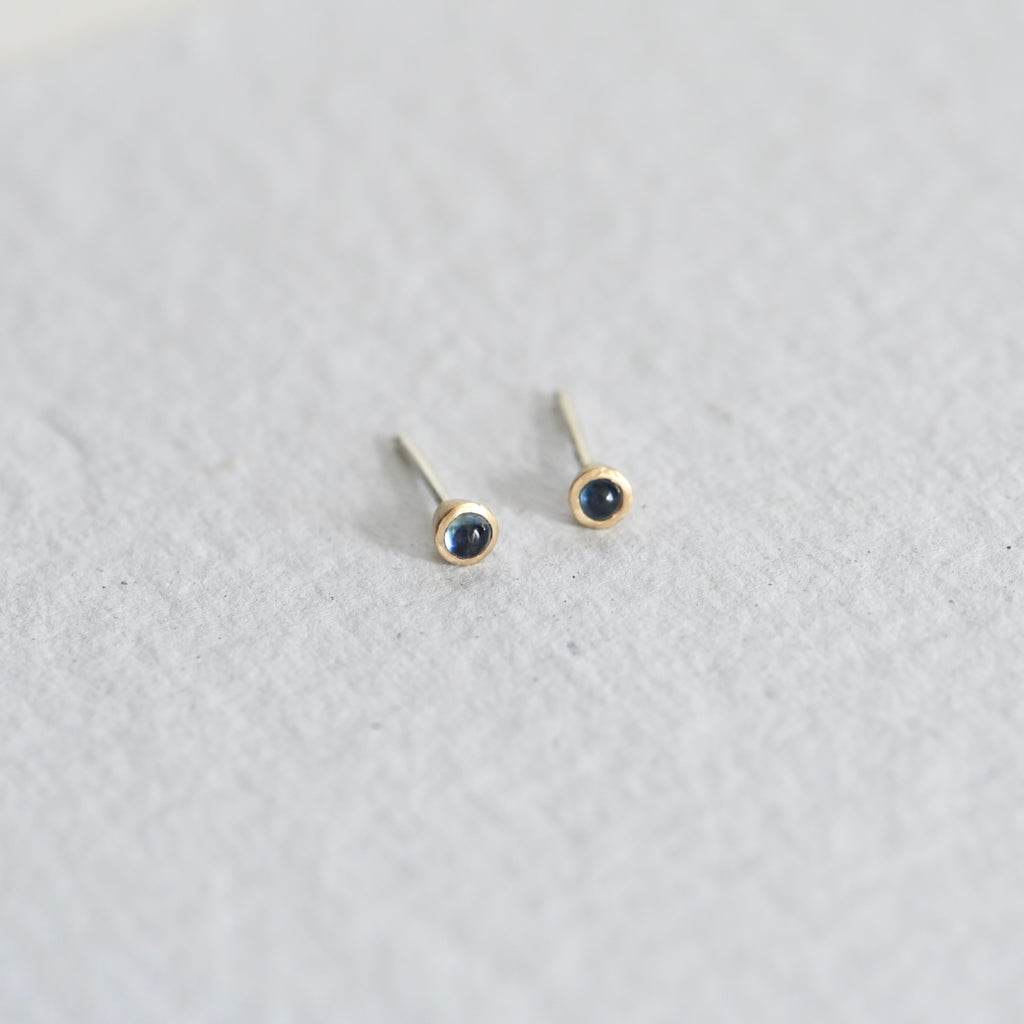 Mixed metal, gold and silver blue cabochon sapphire studs.