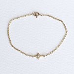A 14k yellow gold cable chain bracelet with a sparkle charm and diamond engraving, displayed against a white background.