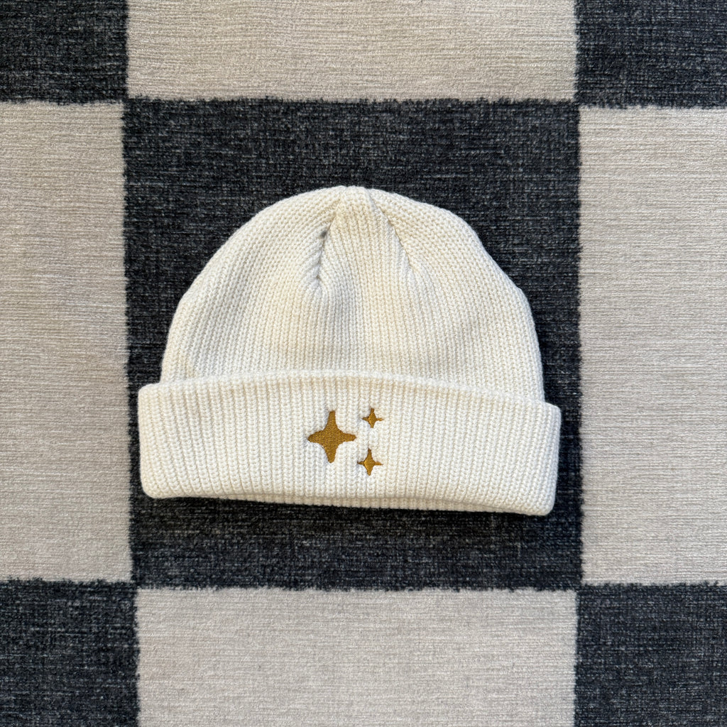 Ecru Sparkle Fisherman Beanie - soft ecru-colored ribbed knit beanie with delicate gold embroidered sparkle, perfect for a cozy and chic look.