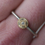 Gold ring with a textured design worn on a finger