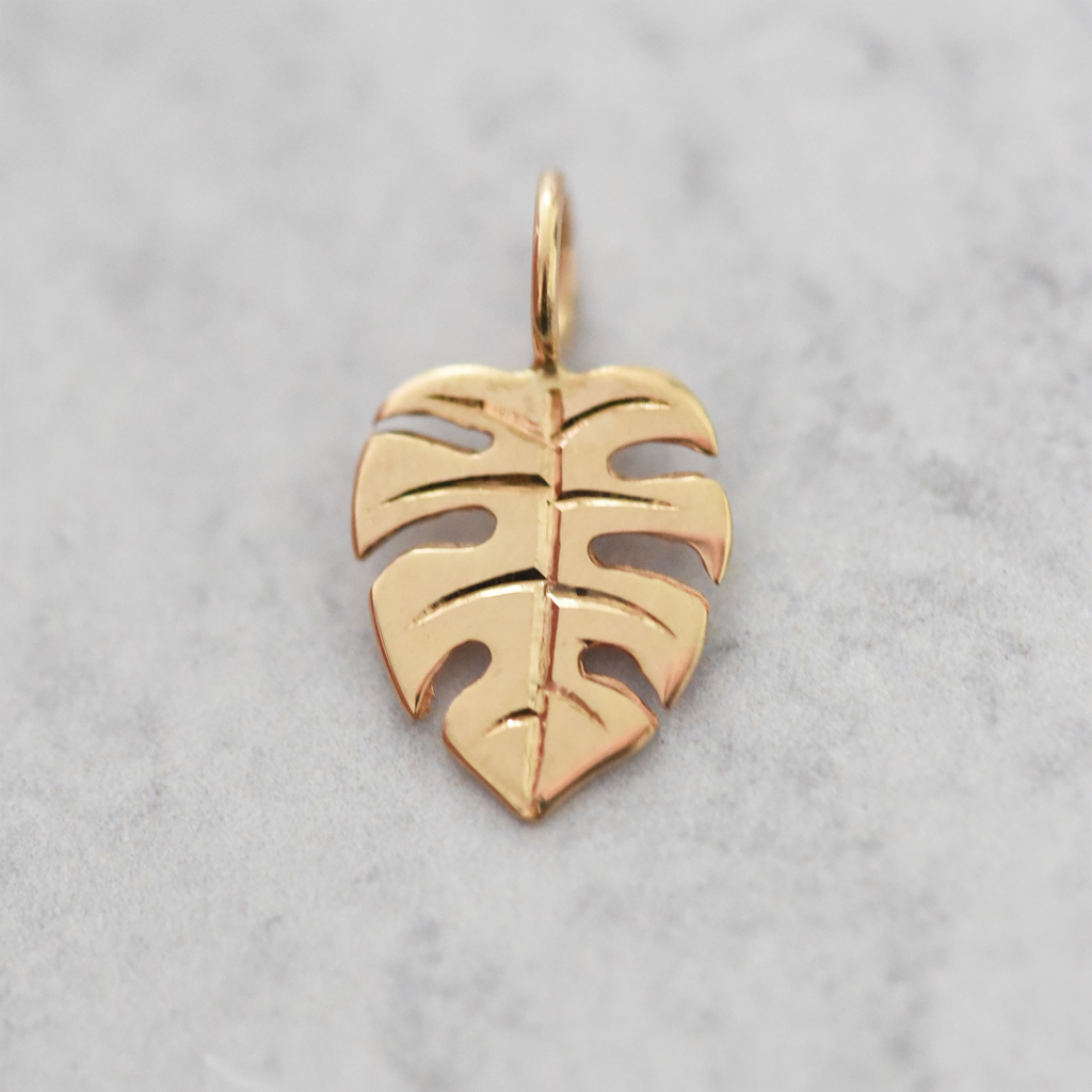 Solid 14k yellow gold monstera charm by Corkie Bolton Jewelry.