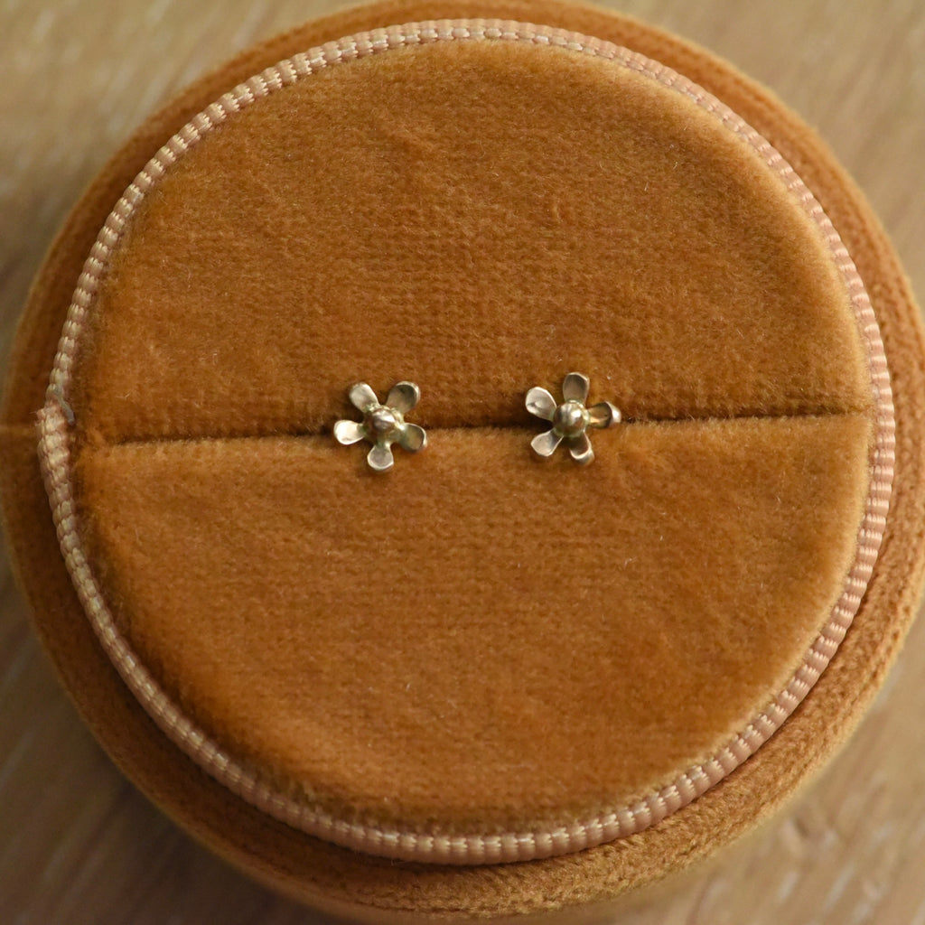 Gold Floret Studs in 14k Yellow Gold resting in a yellow velvet round box.