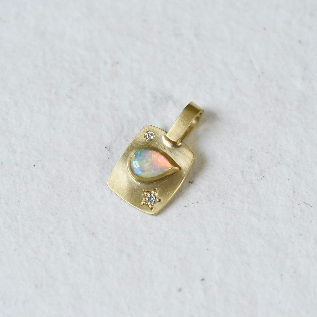  !8k yellow gold rectangular charm with a pear shaped Coober Pedy Australian Opal and diamonds. Hand engraved.