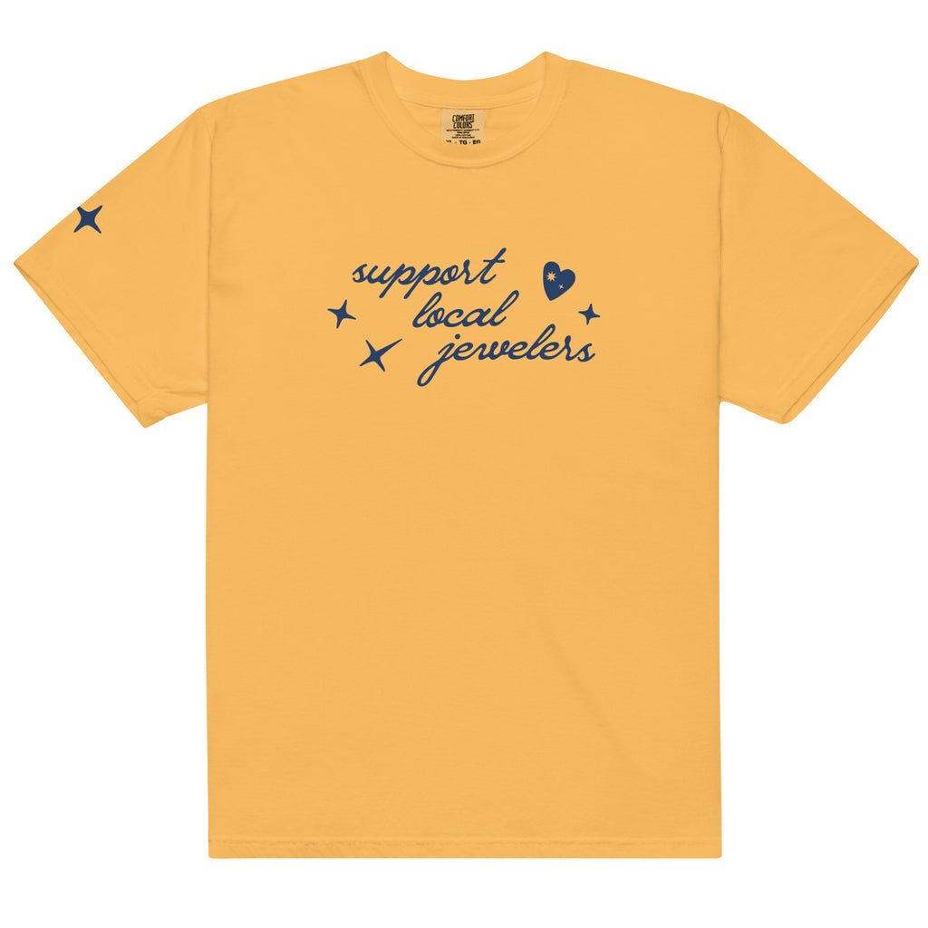 Yellow (Mustard), short-sleeve T-shirt with a navy blue design on the front. The design includes the phrase "support local jewelers" in cursive font, accompanied by small star-like shapes and a heart with a sparkle inside. A small star detail is featured on the left sleeve.