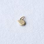 The backside of 1 teardrop flashy opal set in 14k gold as a charm. It is hand engraved with the word HOPE and 14K