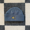 Petrol Blue Sparkle Fisherman Beanie - a neutral blue beanie featuring a gold embroidered sparkle, blending warmth and a sophisticated shimmer for a standout accessory.