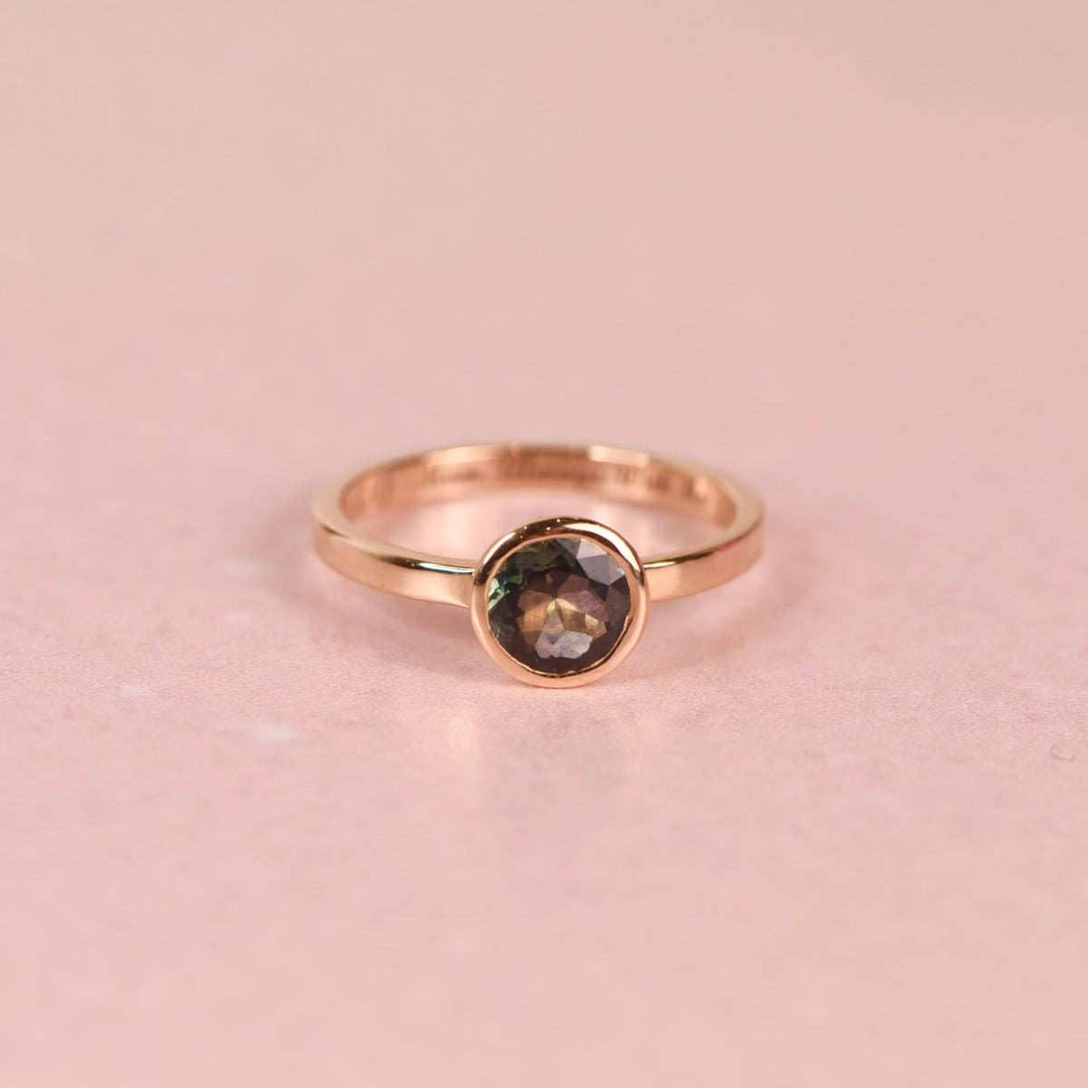 Teal sapphire in a hand fabricated 14k yellow gold bezel on a 2mm 10k yellow gold flat band ring, size 5.5