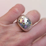 Vintage sterling dome ring with 19 hand engraved sapphirte star settings on a hand.