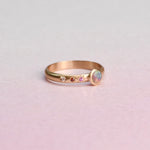 Flat lay of the Asymmetrical Black Opal + Sapphire 14k Gold Ring by Corkie Bolton Jewelry, featuring recycled gold, responsibly sourced gemstones, and delicate star engraving.