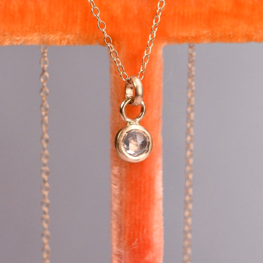14k yellow gold bezel-set rose cut salt and pepper diamond necklace shown from the back with star engraving on the pendant