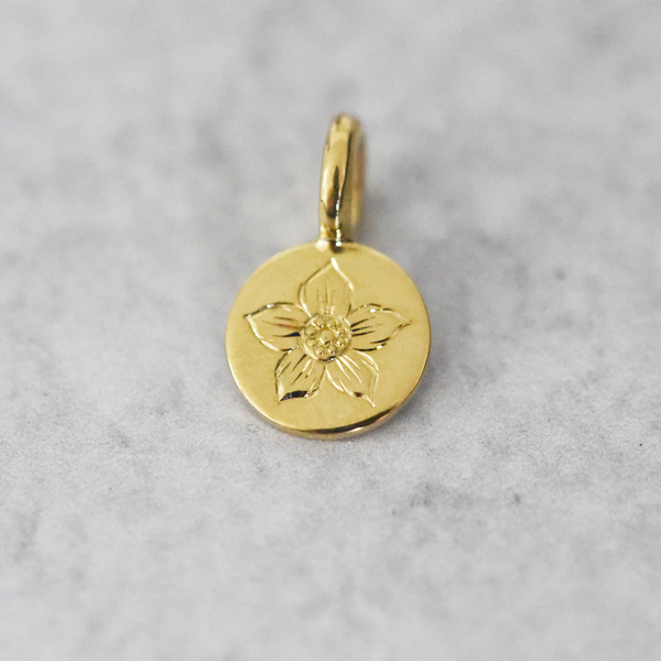 This hand engraved floral charm is crafted from recycled 18k yellow gold created by Corkie Bolton Jewelry.