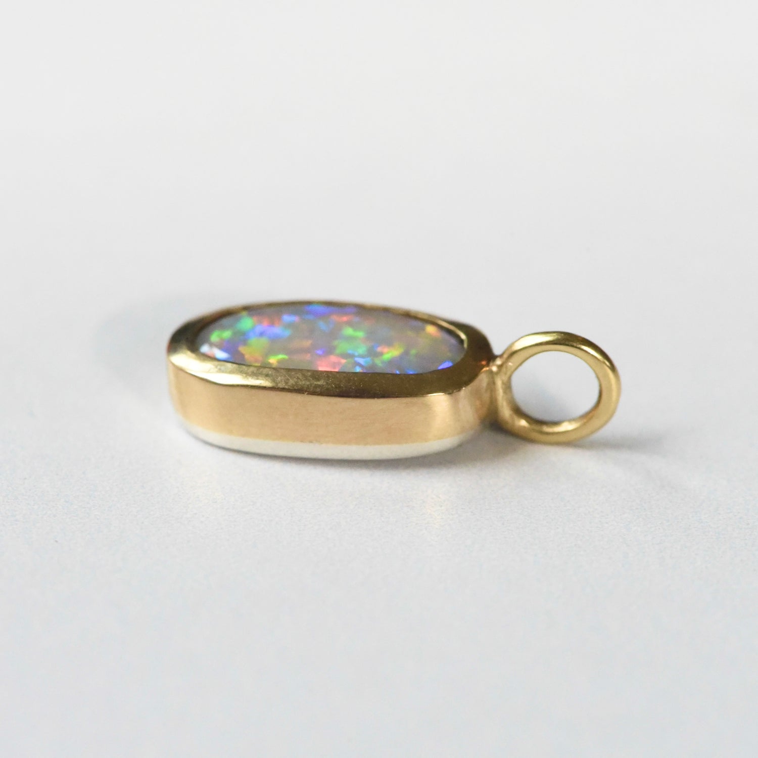 Handmade 22k yellow gold bezel set Lightning Ridge crystal opal pendant, fine silver back, by Corkie Bolton Jewelry Rhode Island on a white background
