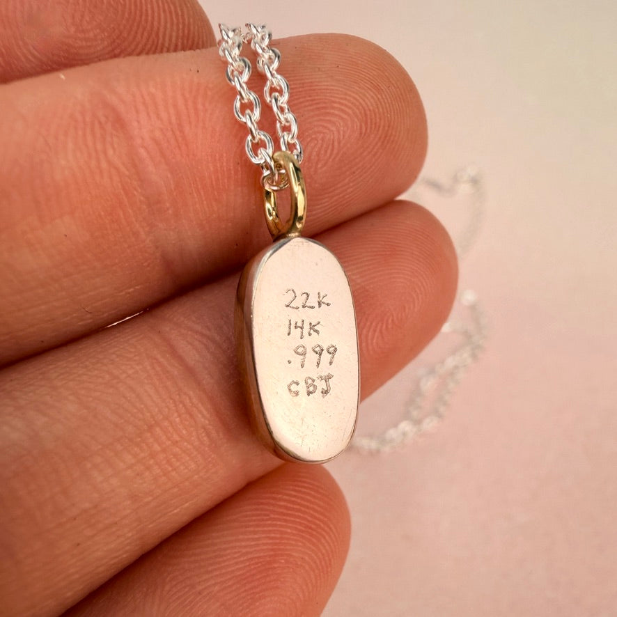 Lightning Ridge crystal opal pendant showing hand stamped 22k 14k and 999 fine silver hallmarks and CBJ maker's mark held in hand
