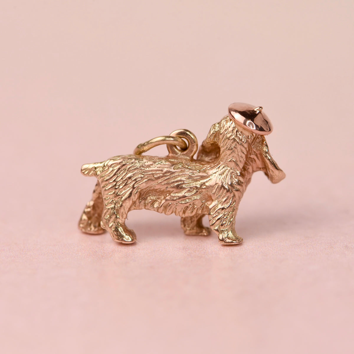Back view of a mid-century 14k gold cocker spaniel charm showing the textured coat, bail, and hand fabricated rose gold beret