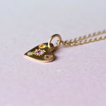 Side view of the Misfit Heart Pendant showing asymmetrical star-set sapphires and diamond with a warm yellow 10k chain.