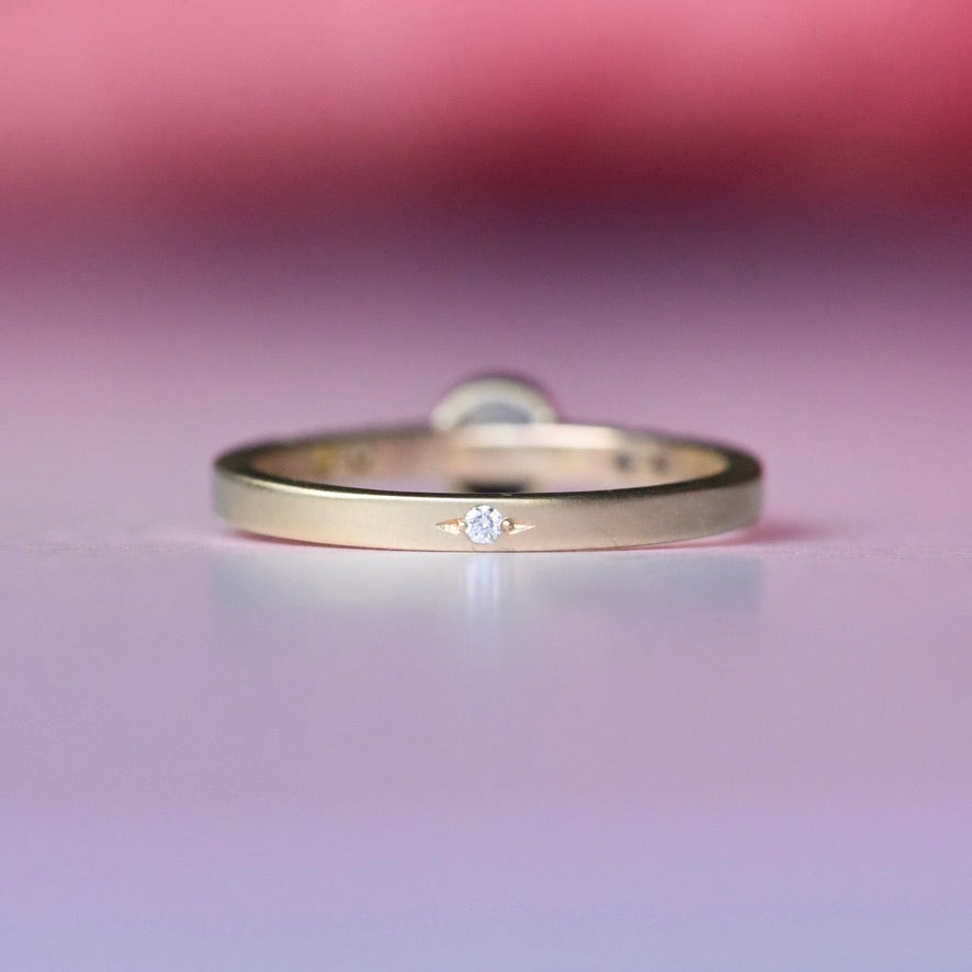 Back view of Montana sapphire ring in 10k yellow gold, showing a hidden diamond detail set inside the band for a unique handcrafted touch.