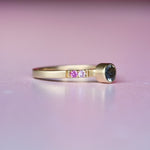 Side angle of Montana sapphire and ombré sapphire ring, highlighting the engraved castle settings, milgrain edges, and satin finish of the 10k yellow gold band.