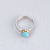 Profile view of the Outstanding Turquoise Mixed Ring, highlighting the 14k gold bezel setting around the turquoise stone and matte finnish silver band. Made by Corkie Bolton Jewelry.