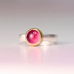 Side detail of a pink tourmaline cabochon set in a buttery 18k yellow gold bezel on a vintage sterling silver ring
