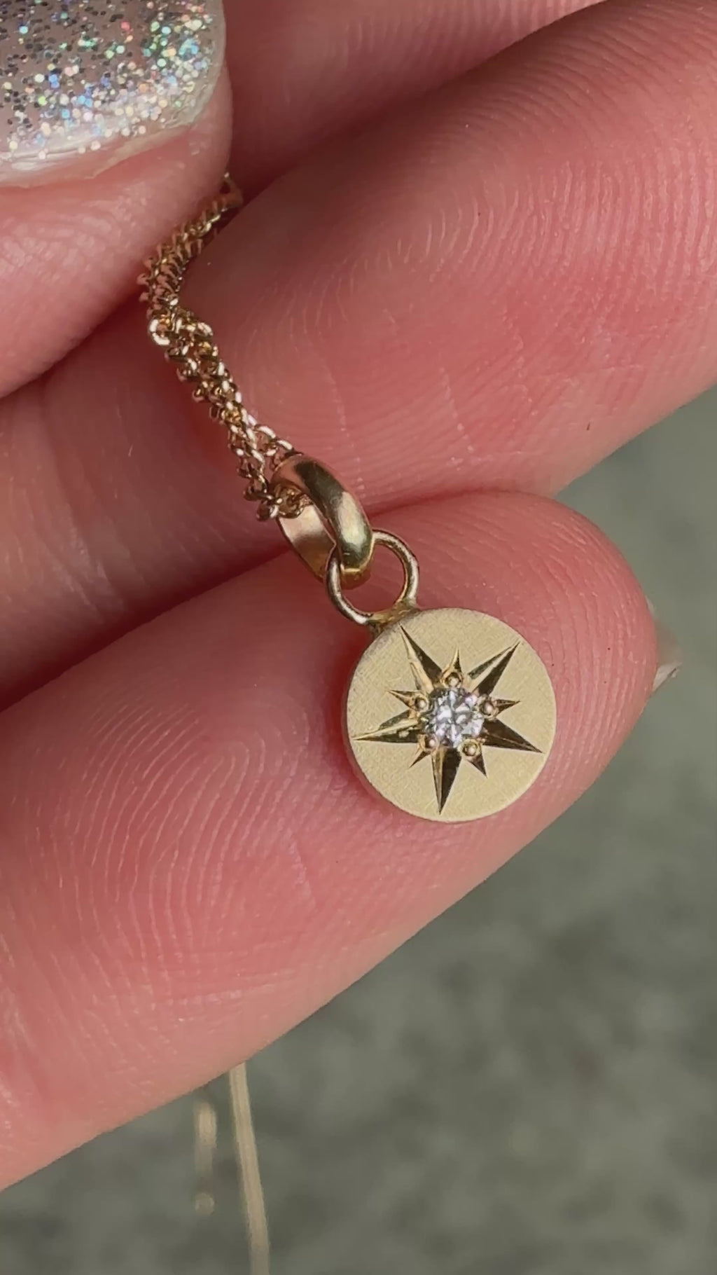 Video of 14k gold necklace featuring a hand-engraved star-set diamond charm on a curb chain