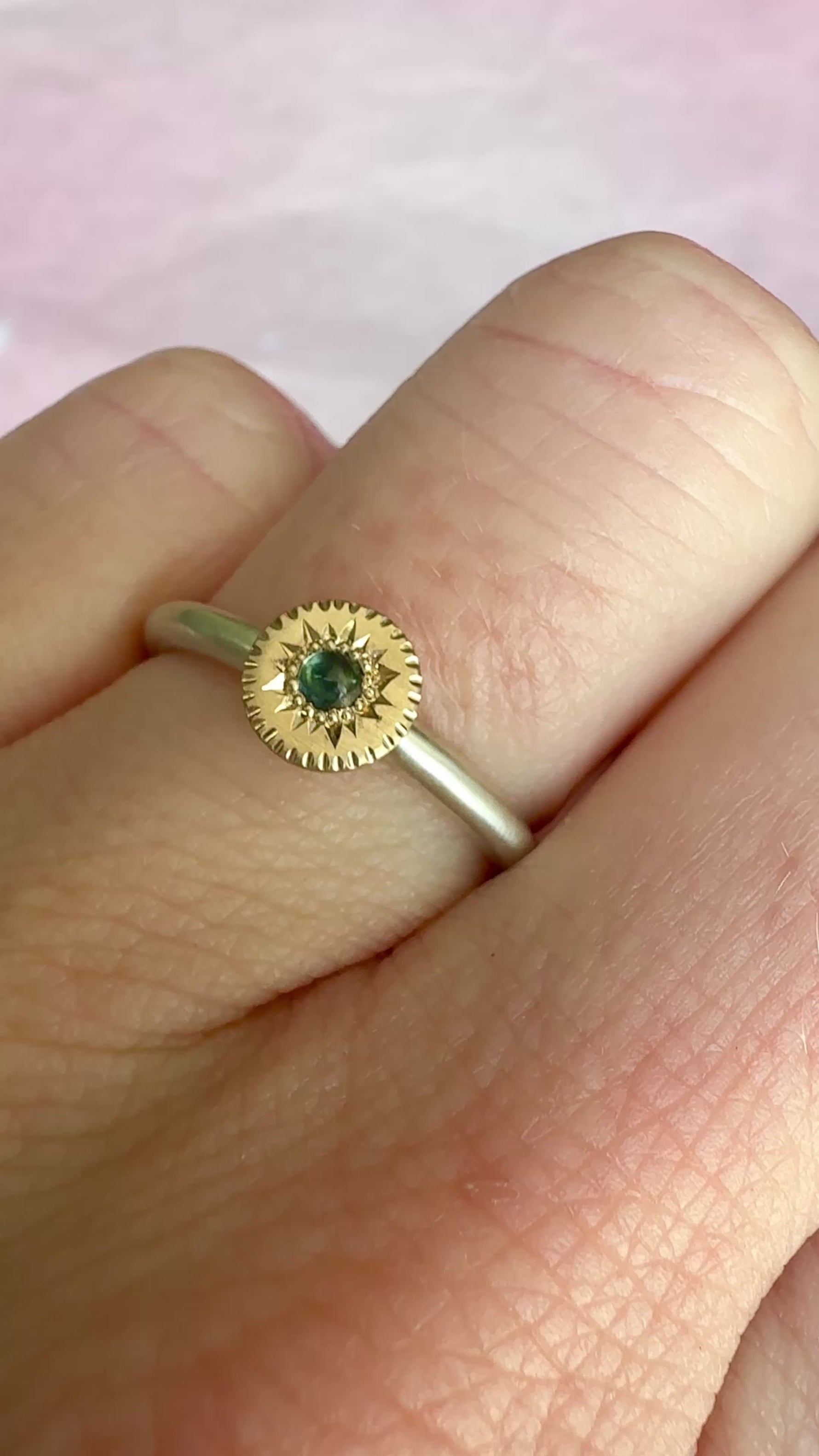 Video of Engraved Starburst Silver and 14k Gold Sapphire Ring rotating under natural light, showing the star-set sapphire and fine hand engraving by Corkie Bolton Jewelry.
