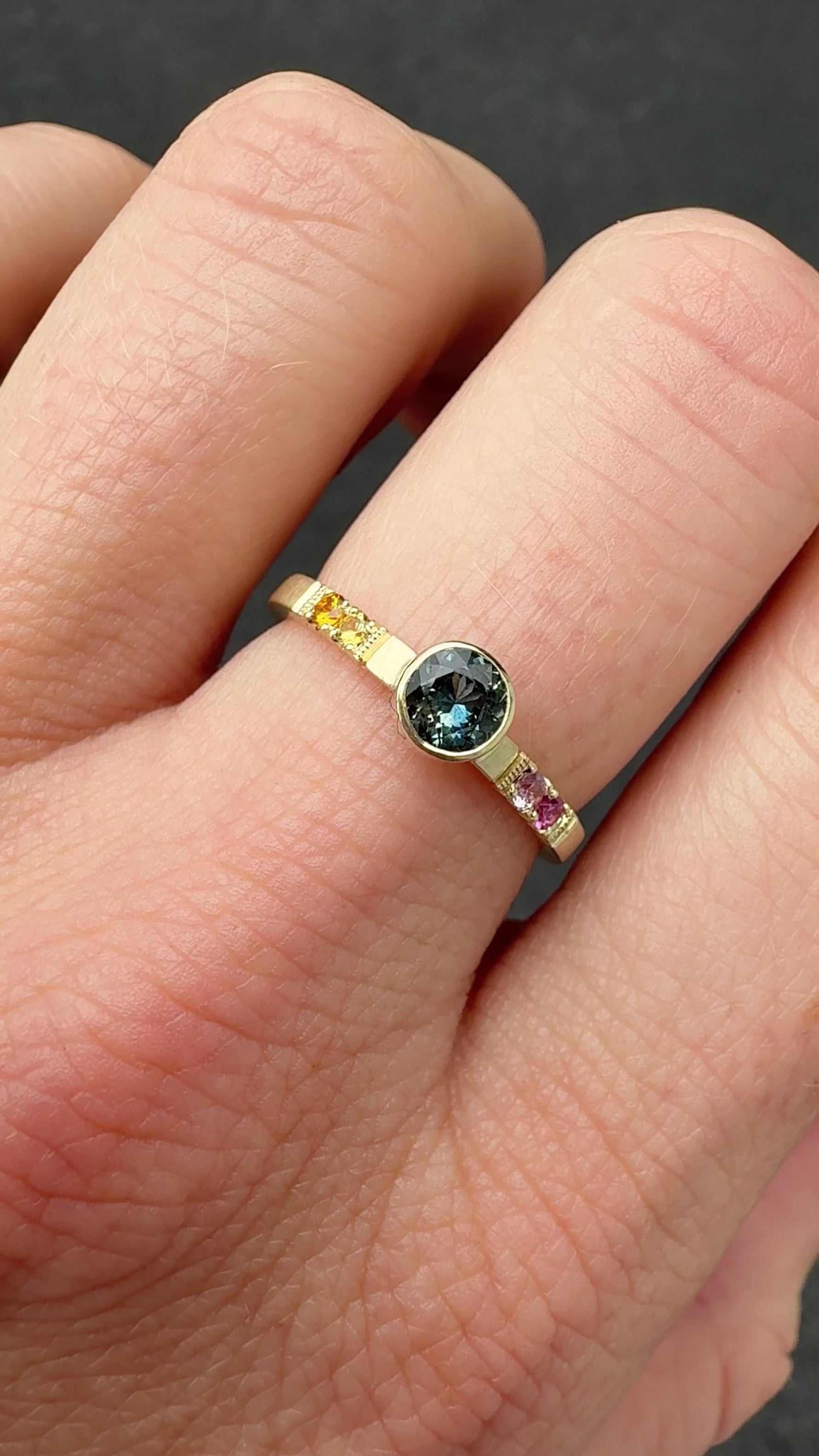Video of Montana sapphire ombré ring worn on hand, showing the .50ct Montana sapphire, colorful ombré of sapphires, and hidden diamond detail in 10k yellow gold with satin finish.