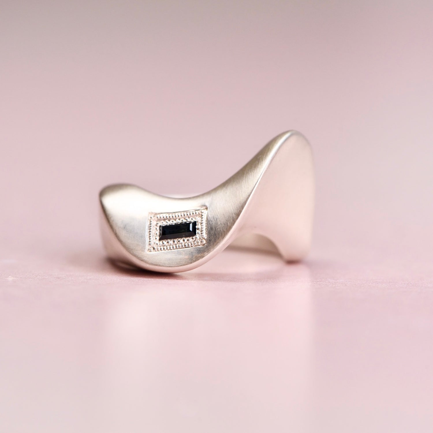 Reborn Vintage sapphire baguette ring by Corkie Bolton Jewelry, highlighting its flowing silhouette, engraved details, an timeless vintage-meets-modern design.