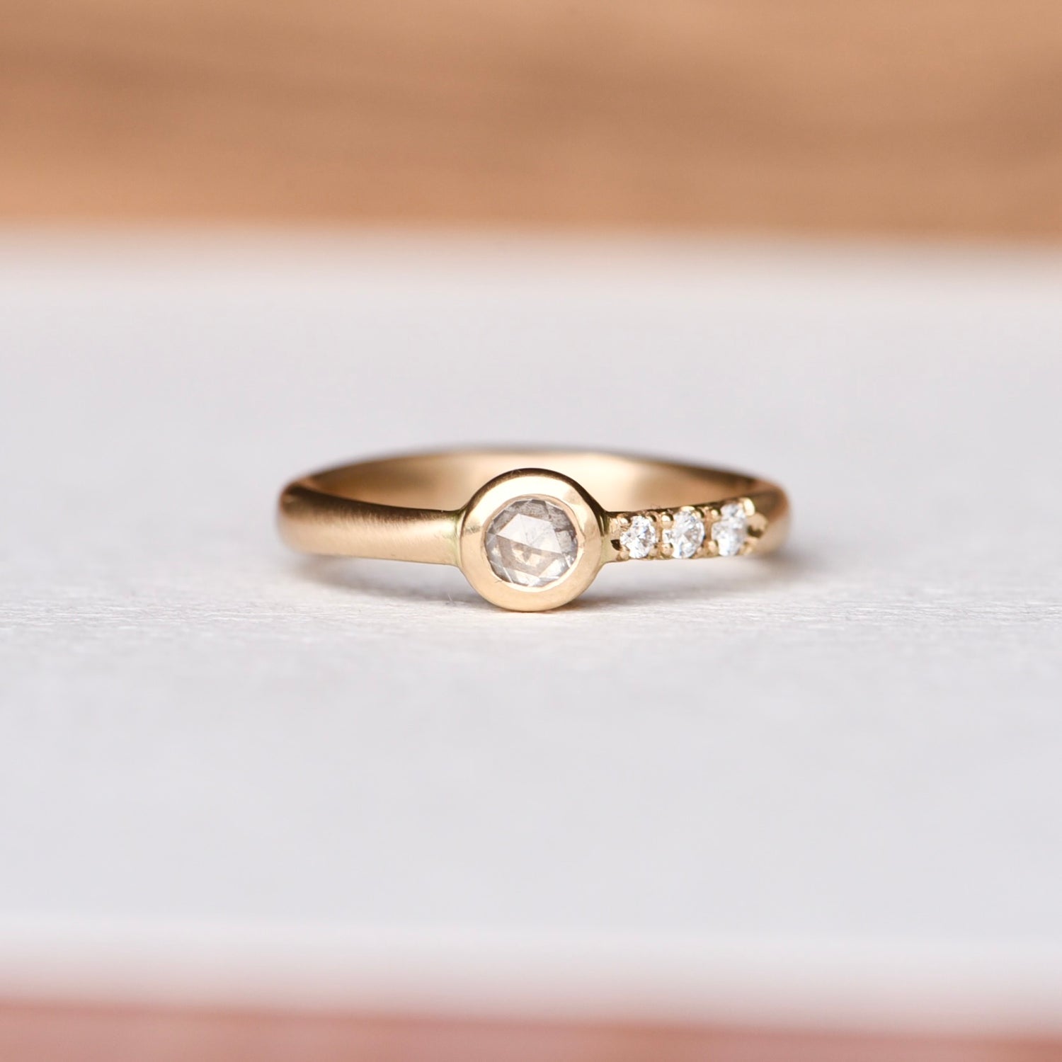 Handcrafted 14k yellow gold ring featuring a 4mm ice rose cut salt and pepper diamond, responsibly sourced from Misfit Diamonds. The band is hand-engraved with tapered diamond pavé on one side. Size 6.25.