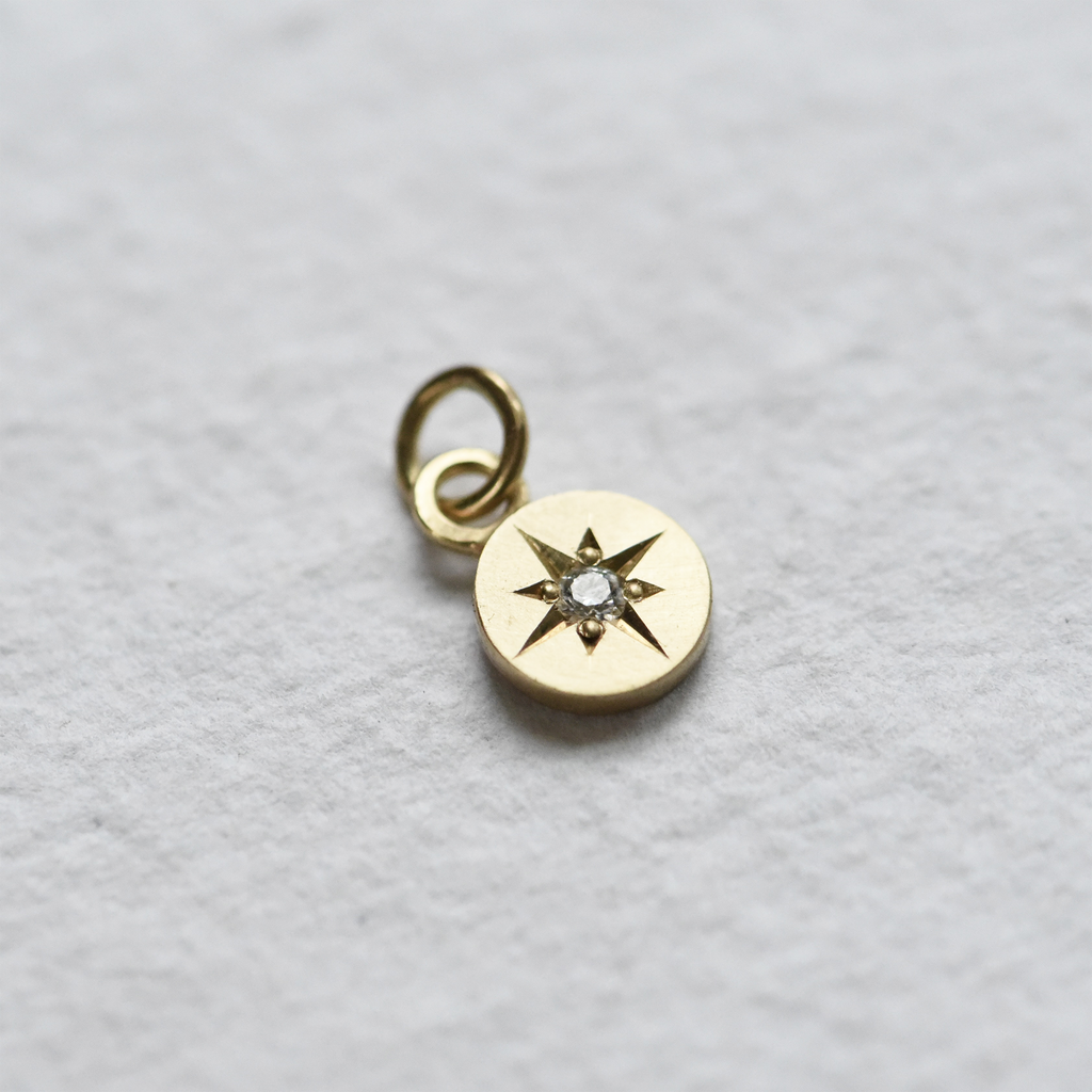 Hand engraved diamond star setting on a round gold pendant by Corkie Bolton Jewelry