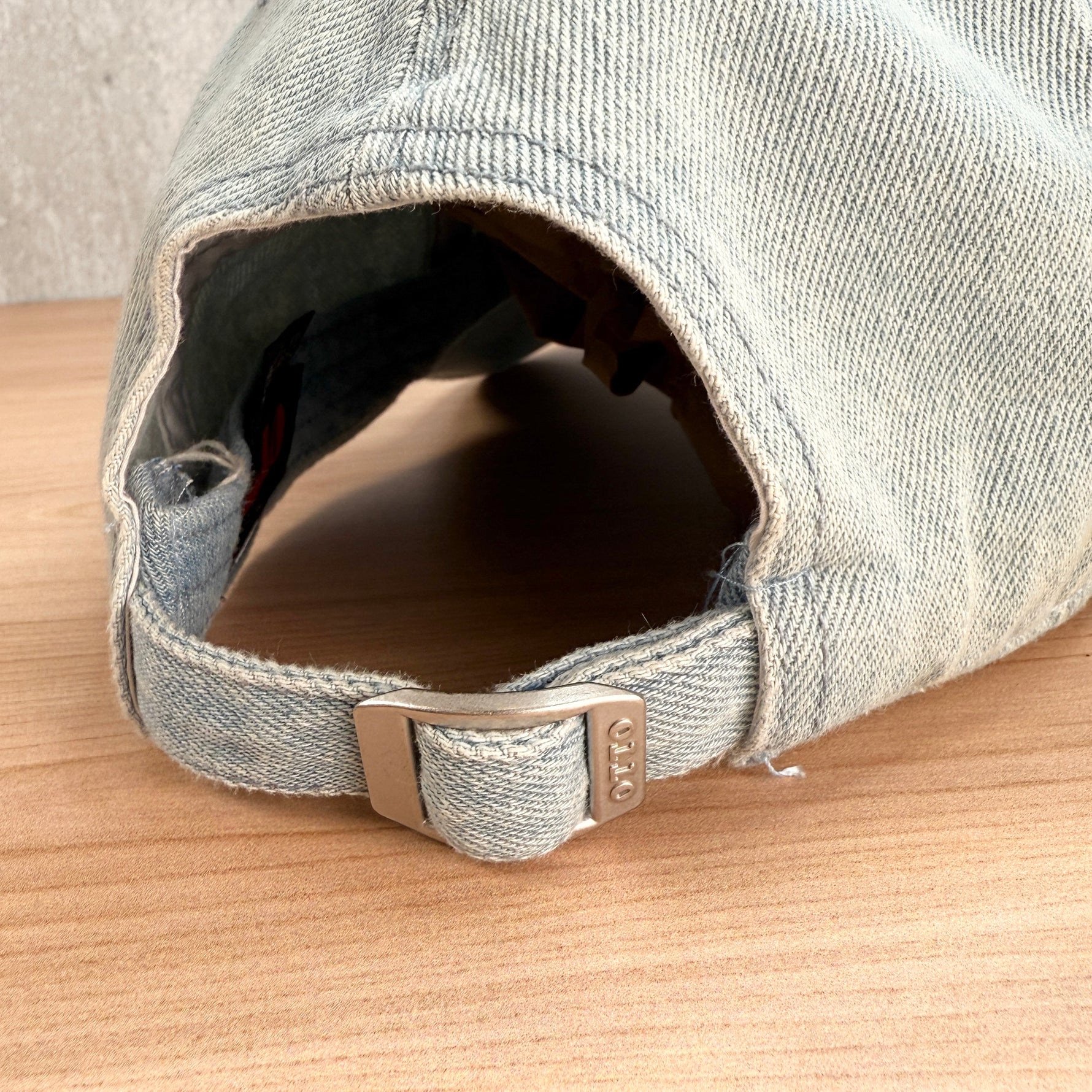 Back view of the light denim Support Local Jewelers hat showing the adjustable strap and clasp. Made from 100% cotton for a soft, breathable fit and finished with white embroidery.