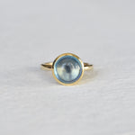 Close-up of Traveler Aquamarine 14k Gold Ring on White Background – A beautiful aquamarine gemstone set in a 14k gold ring. The oval-cut, light blue aquamarine sits in a smooth gold bezel, showcasing its soft, ocean-like hue.