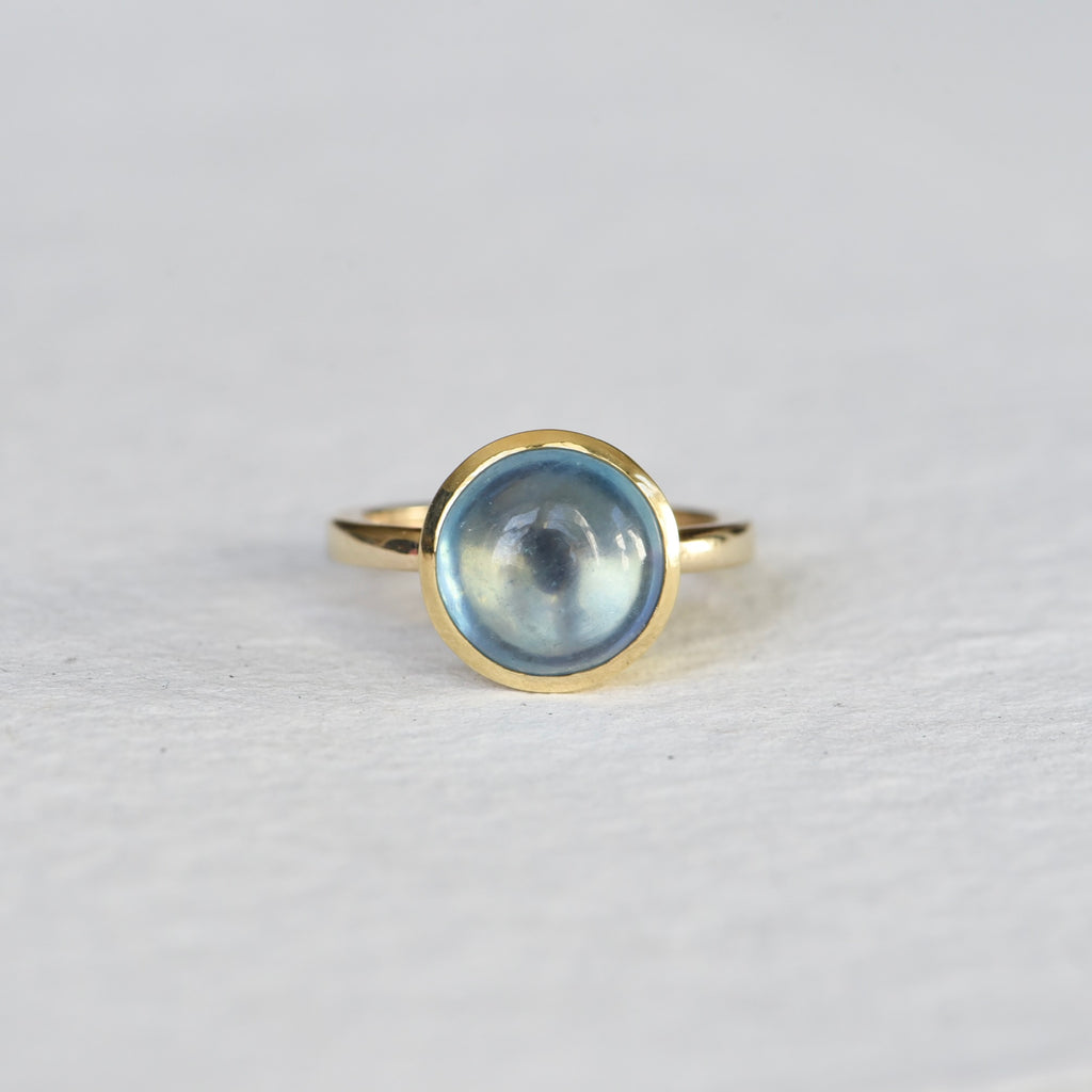 Close-up of Traveler Aquamarine 14k Gold Ring on White Background – A beautiful aquamarine gemstone set in a 14k gold ring. The oval-cut, light blue aquamarine sits in a smooth gold bezel, showcasing its soft, ocean-like hue.