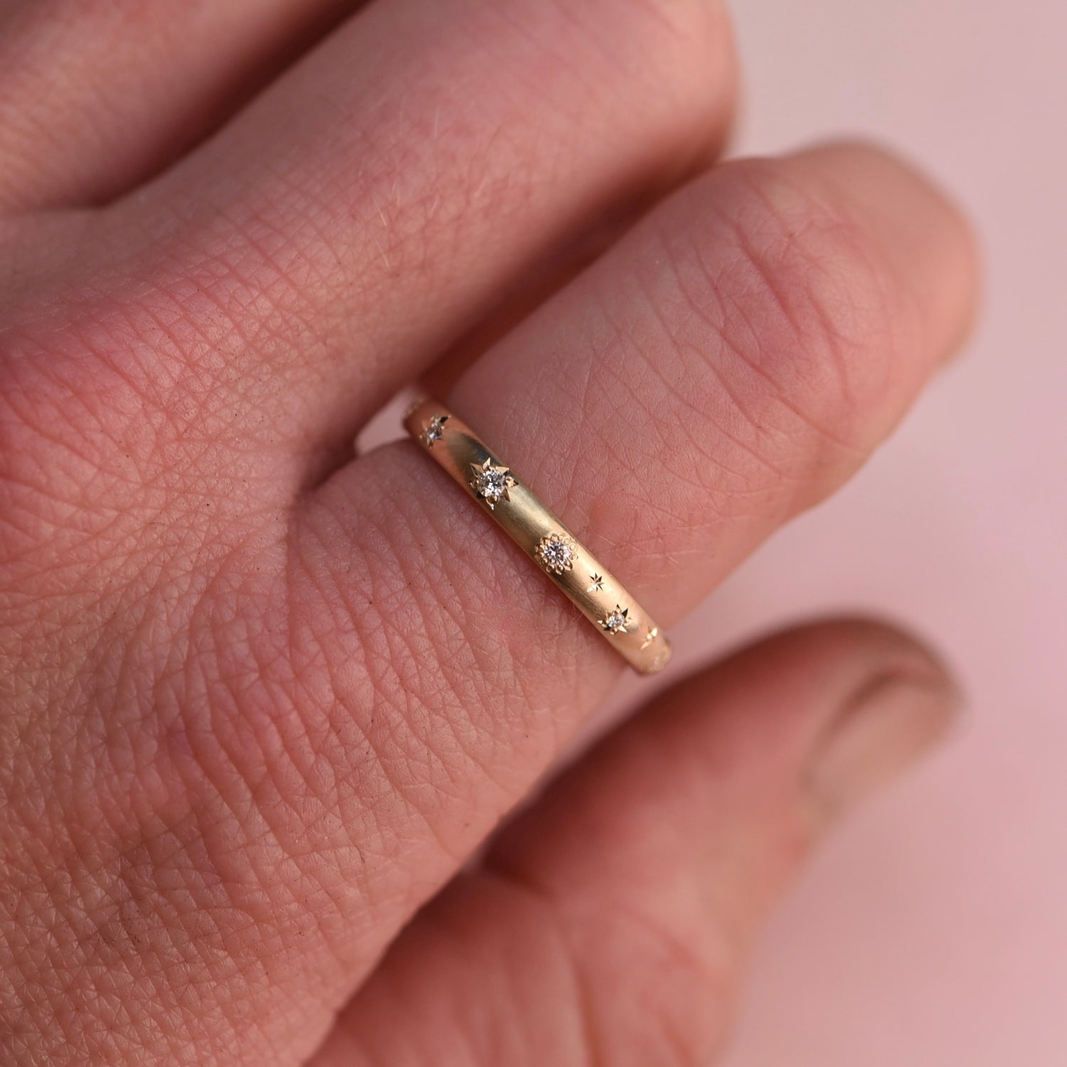 Vintage Celestial Diamond Band worn on hand, showing its subtle sparkle and warm 14k gold tone, handcrafted by Corkie Bolton Jewelry in Rhode Island.