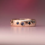Reborn Vintage 10k gold ring featuring blue sapphires and misfit diamonds in celestial hand-engraved settings, designed by Corkie Bolton Jewelry.
