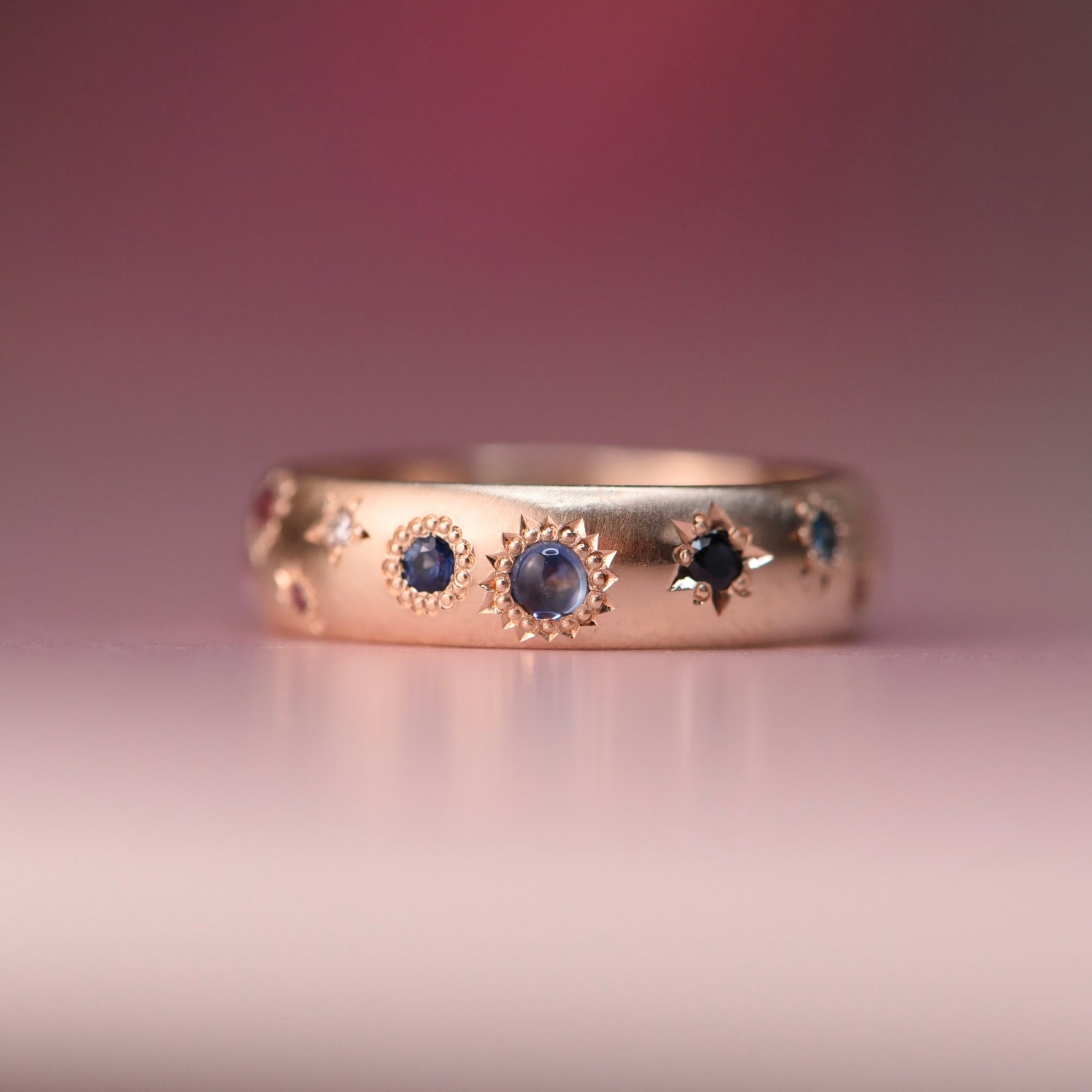 Reborn Vintage 10k gold ring featuring blue sapphires and misfit diamonds in celestial hand-engraved settings, designed by Corkie Bolton Jewelry.