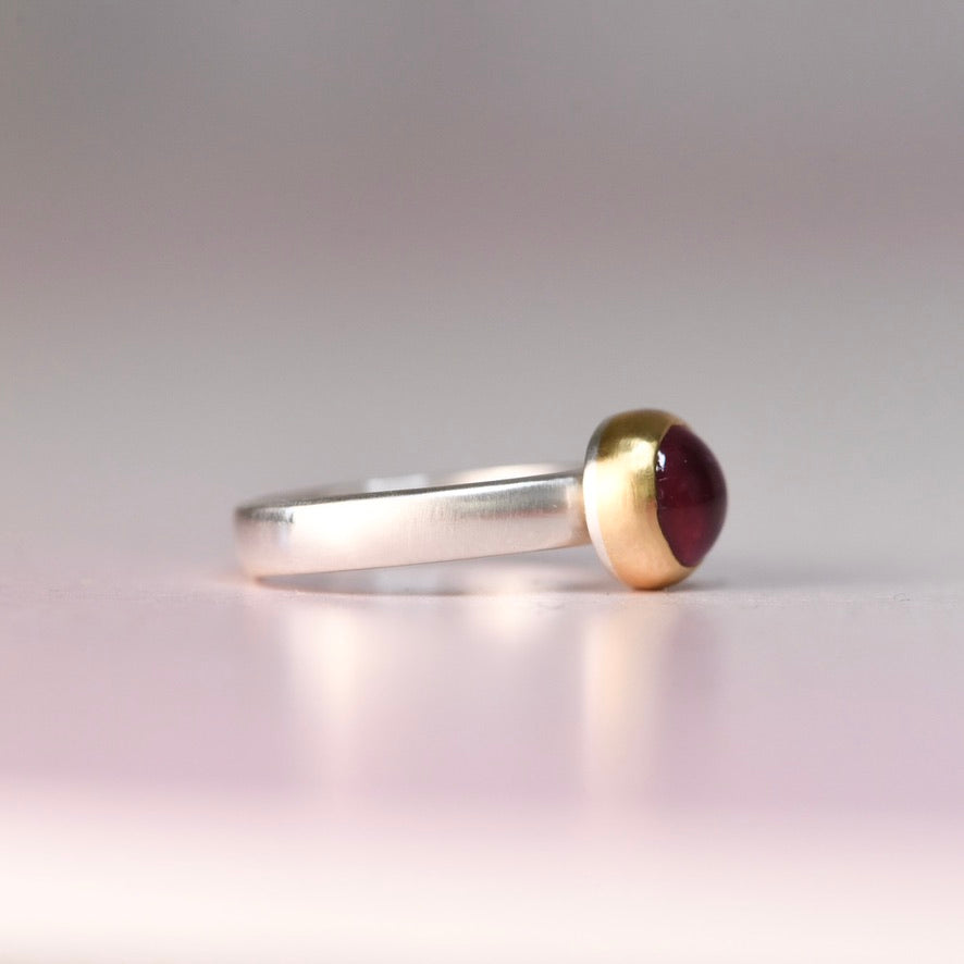 Alternate side detail of a pink tourmaline cabochon set in a buttery 18k yellow gold bezel on a vintage sterling silver ring