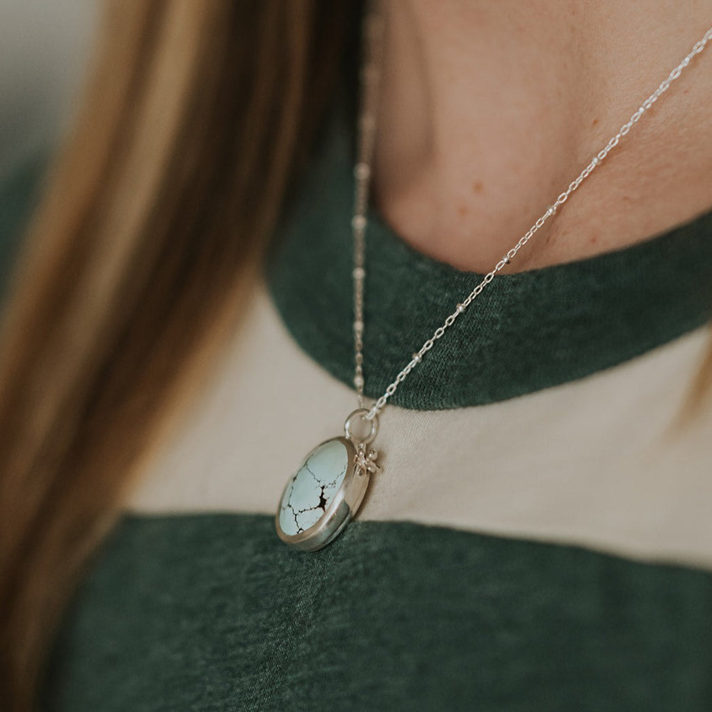 Sterling silver and Sand Hill Turquoise necklace featuring a tiny hand fabricated flower.