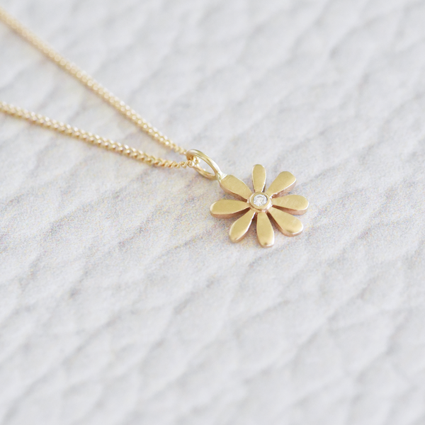 This retro-style, solid 14k yellow gold flower necklace is anything but subtle - sparkling with a small center diamond.