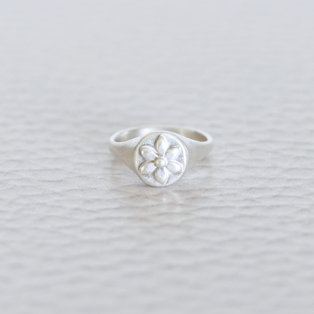 Silver signet ring with a flower. 